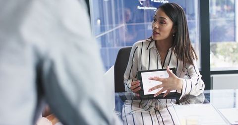 Businesswoman presenting data on tablet in office discussion