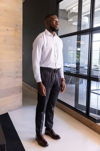 Confident Businessman Standing in Modern Office Corridor