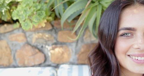 Young woman relaxing on outdoor patio with succulent plants