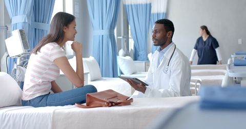 Doctor Consulting Patient in Bright Hospital Ward