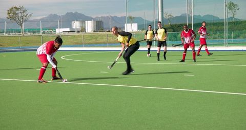 Intense Field Hockey Game in Action on Sunny Day
