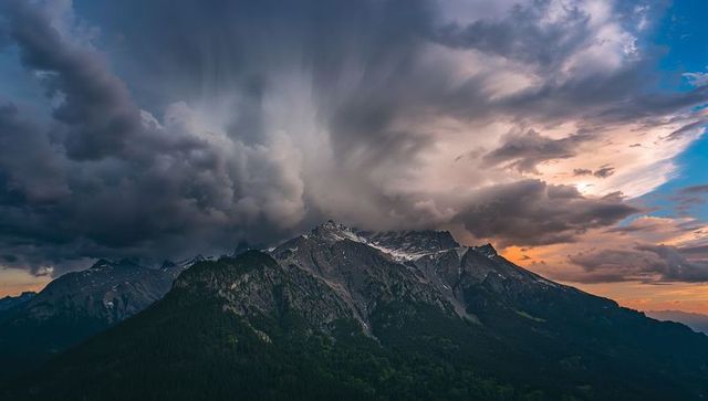 Majestic mountain peaks under stormy sunset skies