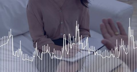 Woman taking notes during consultation with financial data overlay and gesturing hand