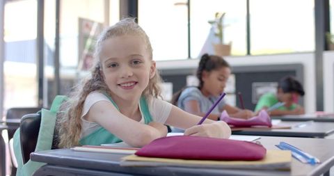 Young Girl Engaging in Classwork Enthusiastically in Bright Classroom - Download Free Stock Images Pikwizard.com