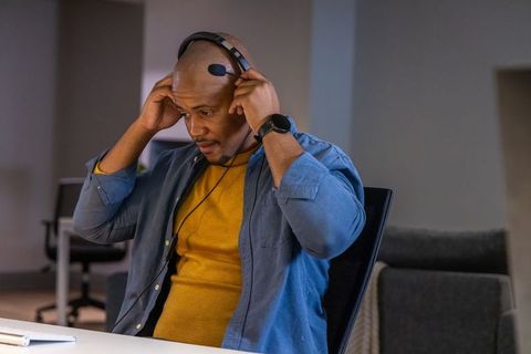 African american man adjusting headset in office preparing for remote support call