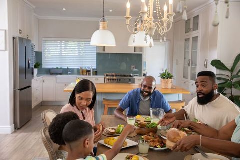 Diverse Family Dining Around Wooden Table in Modern Kitchen