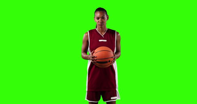 Professional basketball player standing and holding a ball against a green screen background. Perfect for use in sports magazines, advertising athletics or promotional materials, and adding any custom backdrop for flexible media use.