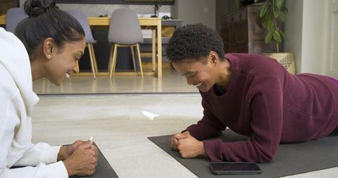 Diverse Female Friends Doing Plank in Modern Living Space for Fitness
