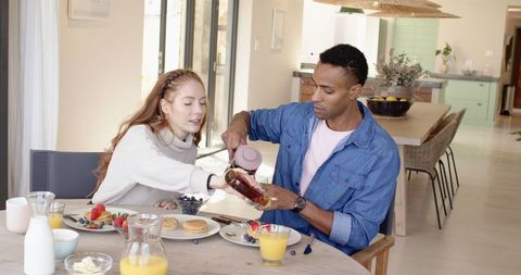 Diverse Couple Enjoying Breakfast with Pancakes and Fresh Juice