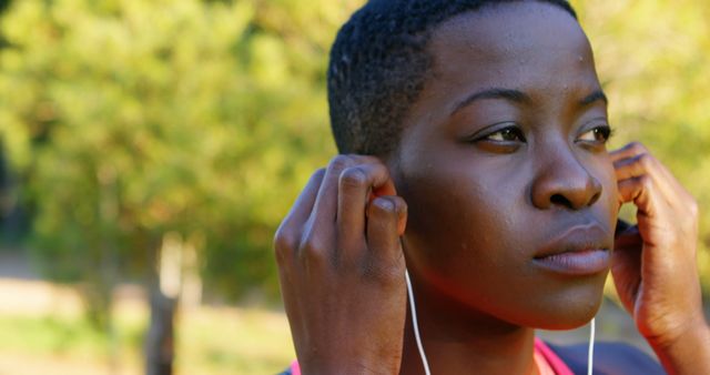 Focused Athlete Adjusting Earbuds During Outdoor Exercise - Download Free Stock Images Pikwizard.com