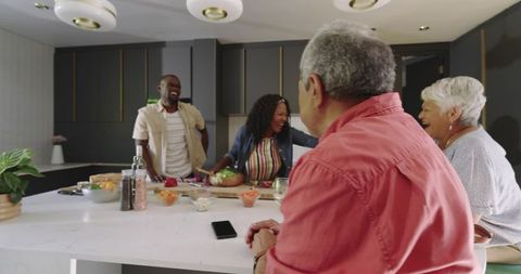 Multigenerational Family Cooking Together at Modern Kitchen Island Laughing Preparing Salad