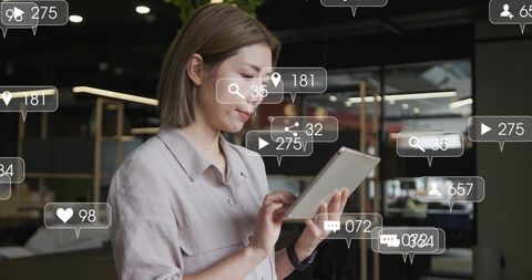 Female Professional Tapping Tablet with Floating Social Media Notifications in Office