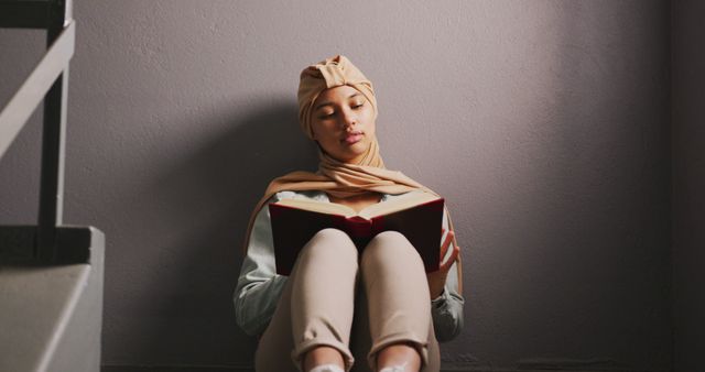 Young Woman in Hijab Reading Book on Floor - Download Free Stock Images Pikwizard.com