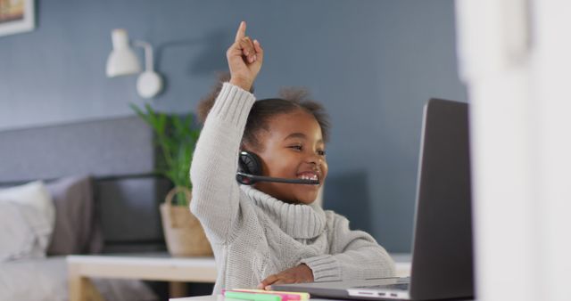 Smiling Child with Headset Raising Hand During Online Learning - Download Free Stock Images Pikwizard.com