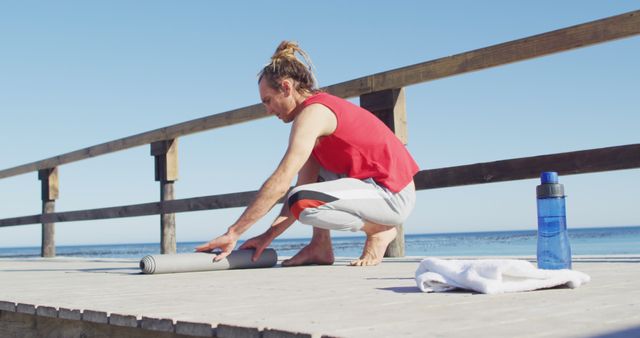 Young Man Rolling Yoga Mat Near Beach - Download Free Stock Images Pikwizard.com