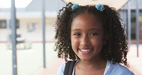 Smiling Biracial Student in School Courtyard with Curly Hair Accessories - Download Free Stock Images Pikwizard.com