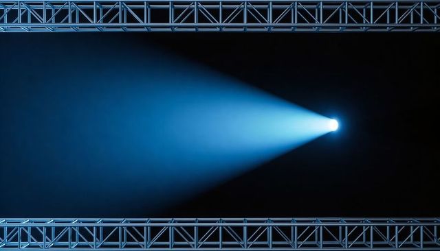 Single blue spotlight casting dramatic cone of light across stage through cinematic haze