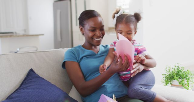 African american daughter giving mother gift on mother's day - Download Free Stock Photos Pikwizard.com