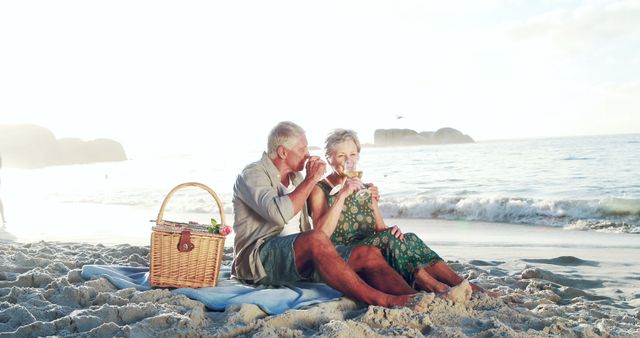 Retired old couple drinking white wine on the beach