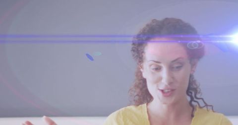 Creative light trails over enthusiastic woman teaching