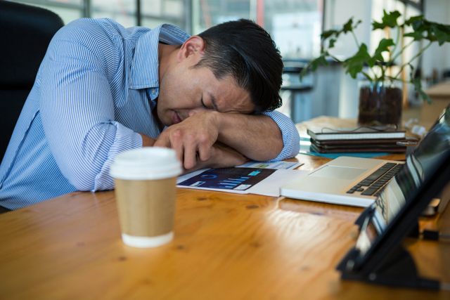 Tired business executive sleeping at desk in office