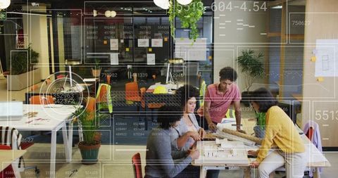Design team collaborating over architectural model in modern coworking studio