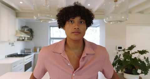 Young man confidently standing in modern kitchen