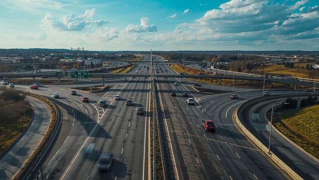 Aerial freeway interchange stretching toward horizon with curved ramps and flowing traffic