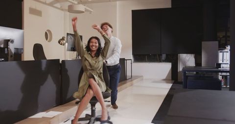Joyful chair race bringing laughter to night shift in modern office