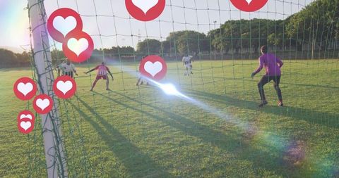 Backlit soccer attack pressing near goalpost with goalkeeper in purple and heart overlays