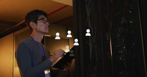 Technician Monitoring Server Room with Tablet