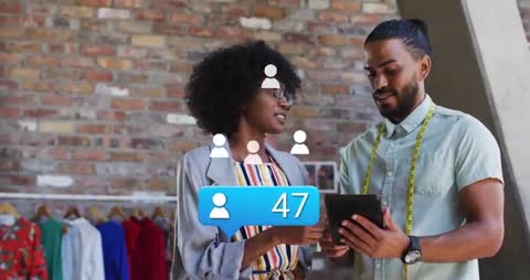 Fashion Designers Using Tablet in Modern Studio with Social Media Icons