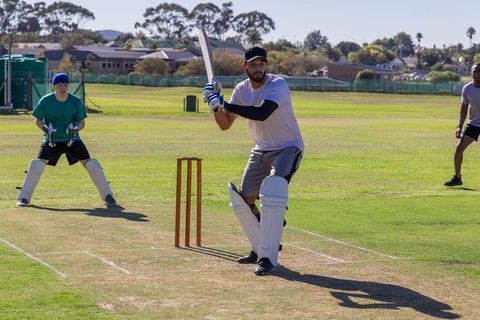 Batsman preparing shot on sunny community cricket pitch