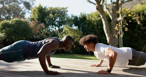 Diverse Friends Doing Push-Ups Outdoors for Strength and Fitness