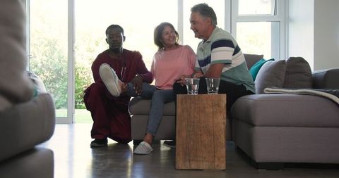 Senior Couple Engaging With Caregiver in Living Room