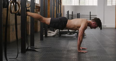 Athletic Man Performing Elevated Push-Up with Gymnastic Rings