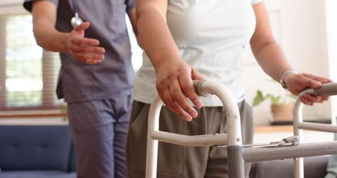 Physiotherapist Assisting Senior Woman with Walker in Living Room - Download Free Stock Images Pikwizard.com