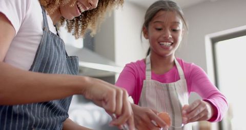Happy Mother and Daughter Baking Together in Home Kitchen Smiling