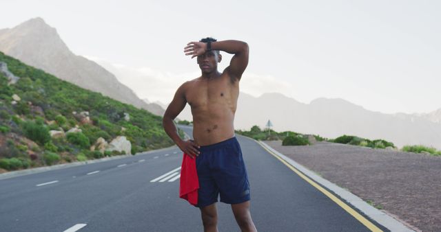 Tired Male Athlete Resting on Mountain Road - Download Free Stock Images Pikwizard.com