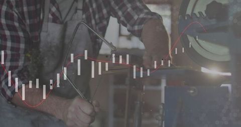 Artisan working at bench holding frame saw with financial candlestick chart overlay