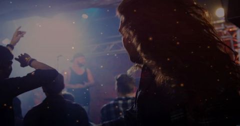 Backlit Long-Haired Fan Dancing in Crowd at Rock Concert with Spotlights and Haze