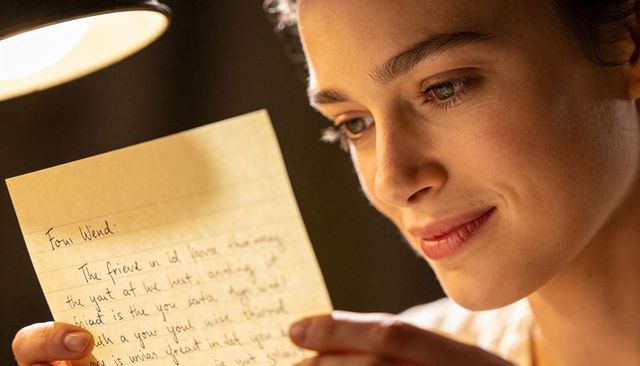 Reading handwritten letter by warm bedside lamp, intimate cozy portrait