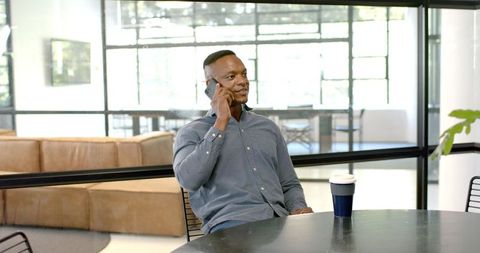 Professional Chat: Man Discussing Business on Phone in Modern Office