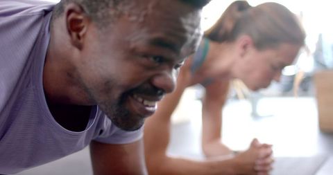Diverse Couple Holding Plank Position in Home Workout Routine