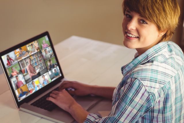 Smiling caucasian girl using laptop for video call, with diverse high school pupils on screen. communication technology and online education, digital composite image.