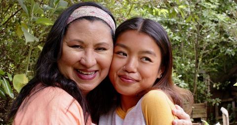 Mother and Young Daughter Embracing with Joy in Green Garden