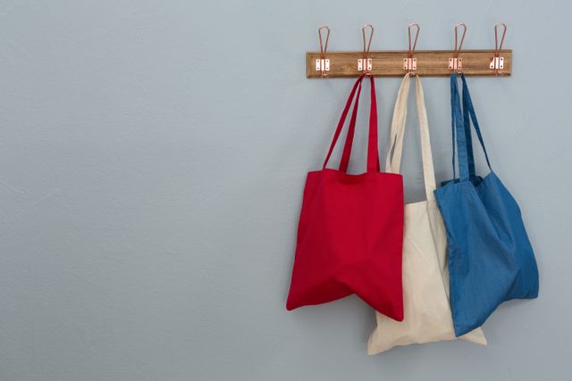 Various handbags hanging on hook against wall