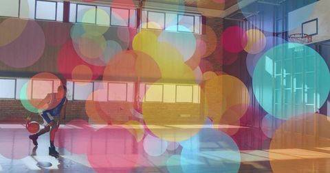 Basketball Player Dribbling in Gym with Colorful Bubble Overlay
