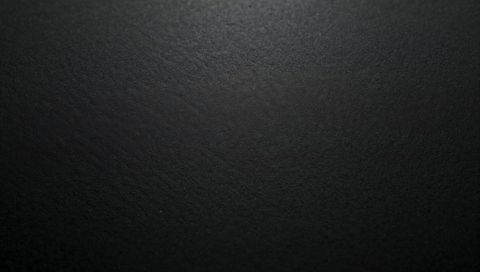 Matte Black Texture Showing Subtle Speckle and Soft Overhead Light