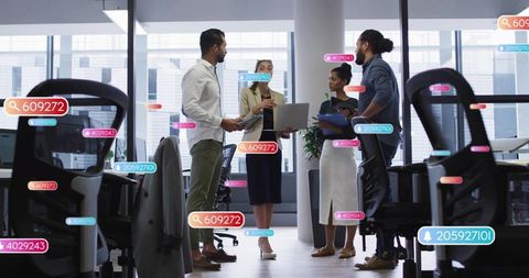 Diverse team collaborating in modern open-plan office using augmented reality tags and digital tools